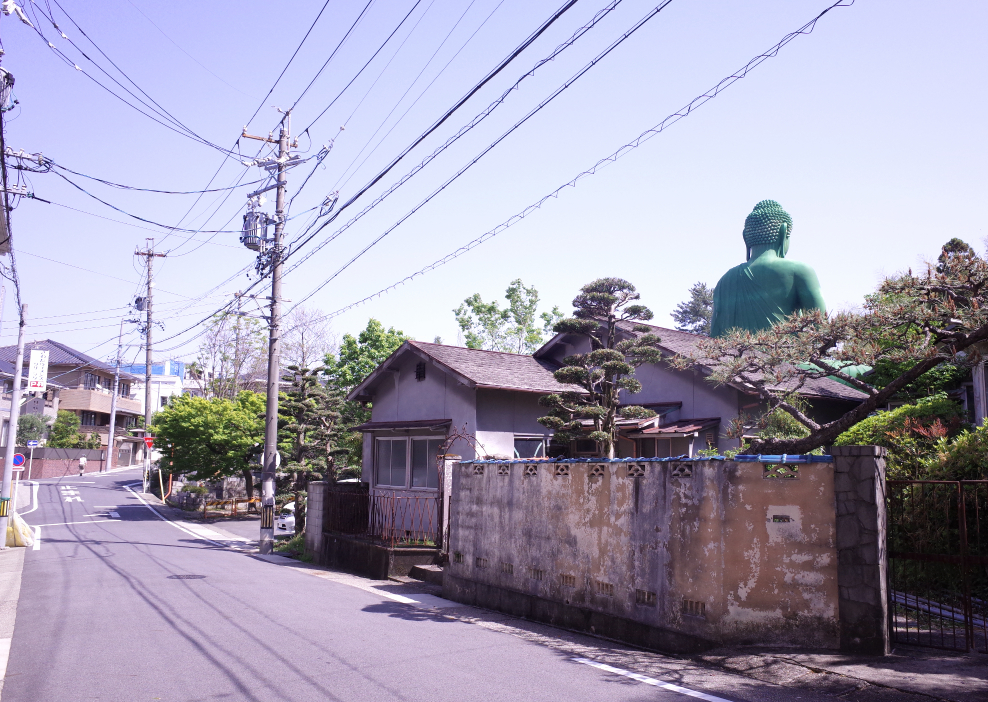 The green Buddha statue stands serenely in a residential area of Nagoya.