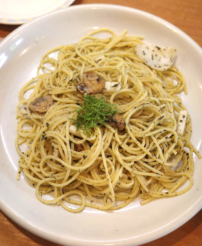 Basil spaghetti topped with squid.