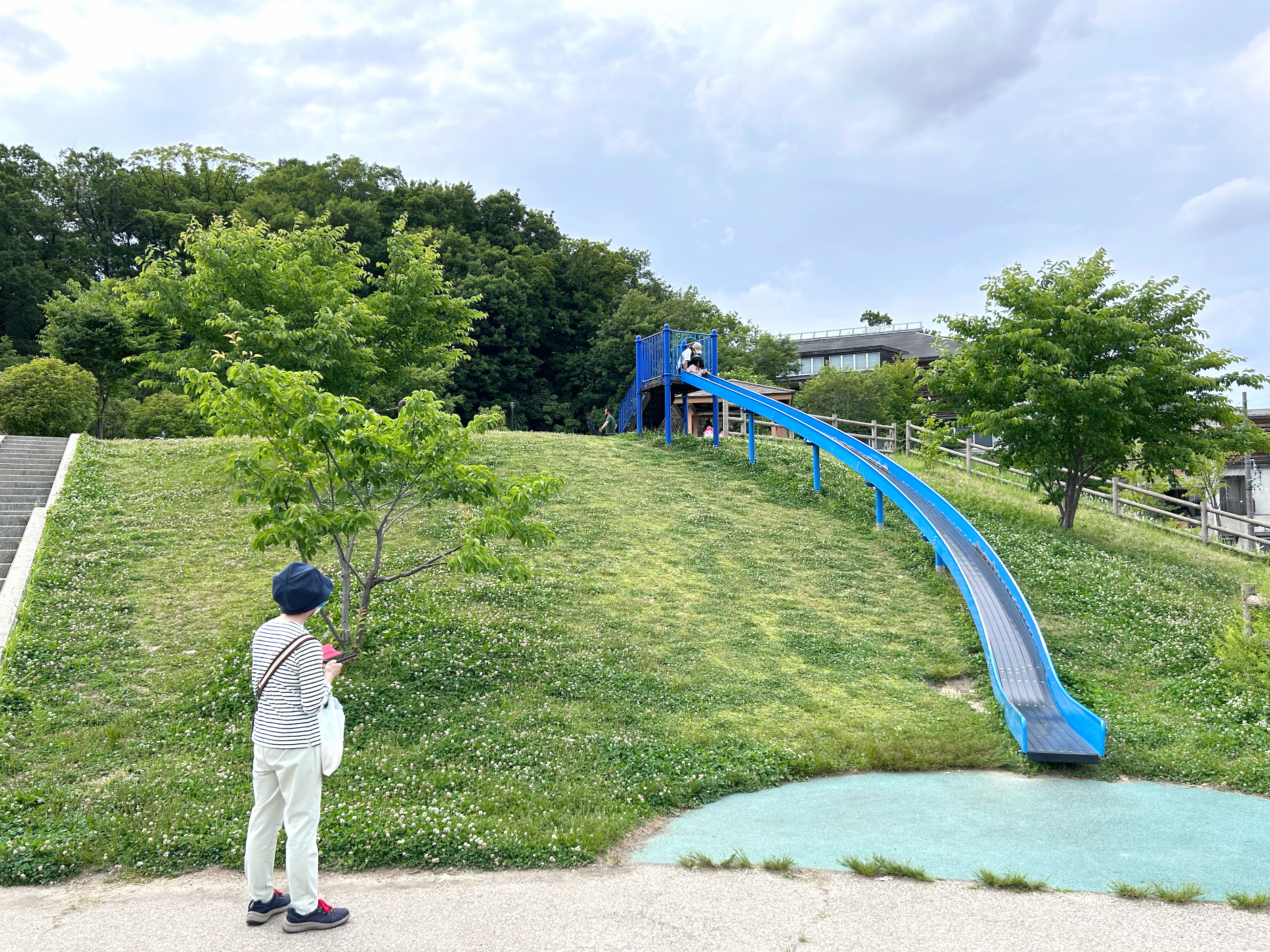 The grandmother watches her grandchildren sliding down.