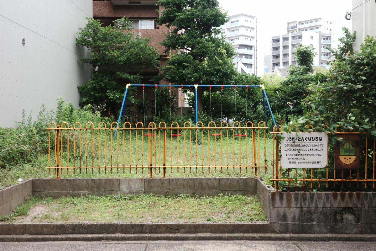 A small neglected park across the shopping street.