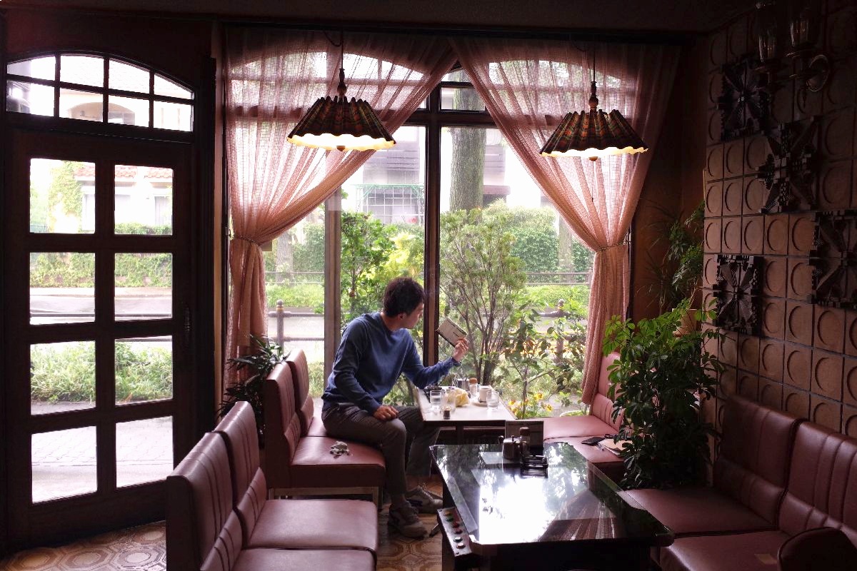 A man sitting at a local coffee shop in Nagoya, pondering if Nagoya is worth visiting