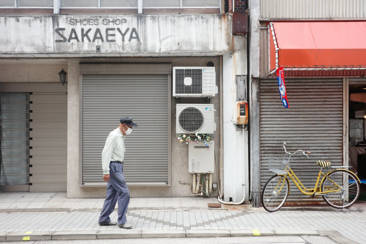 Senior man enjoying a leisurely walk at Tsukijiguchi Shotengai, one of Nagoya hidden gems.