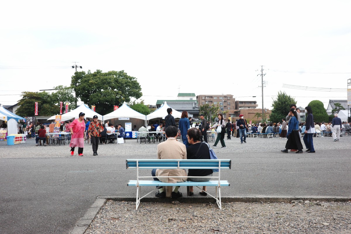 A ld couple sitting down and relaxing, enjoying the serene atmosphere at the Thai Festival in Nittai-ji, Nagoya.