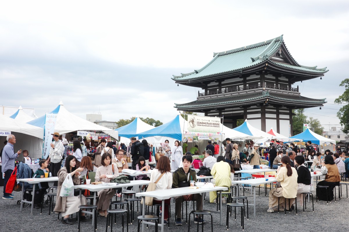 Visitors sitting down and relaxing, enjoying the serene atmosphere at the Thai Festival in Nittai-ji, Nagoya.