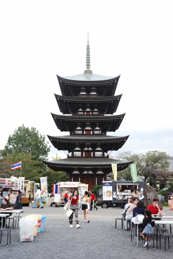 Visitors sitting down and relaxing, enjoying the serene atmosphere at the Thai Festival in Nittai-ji, Nagoya.