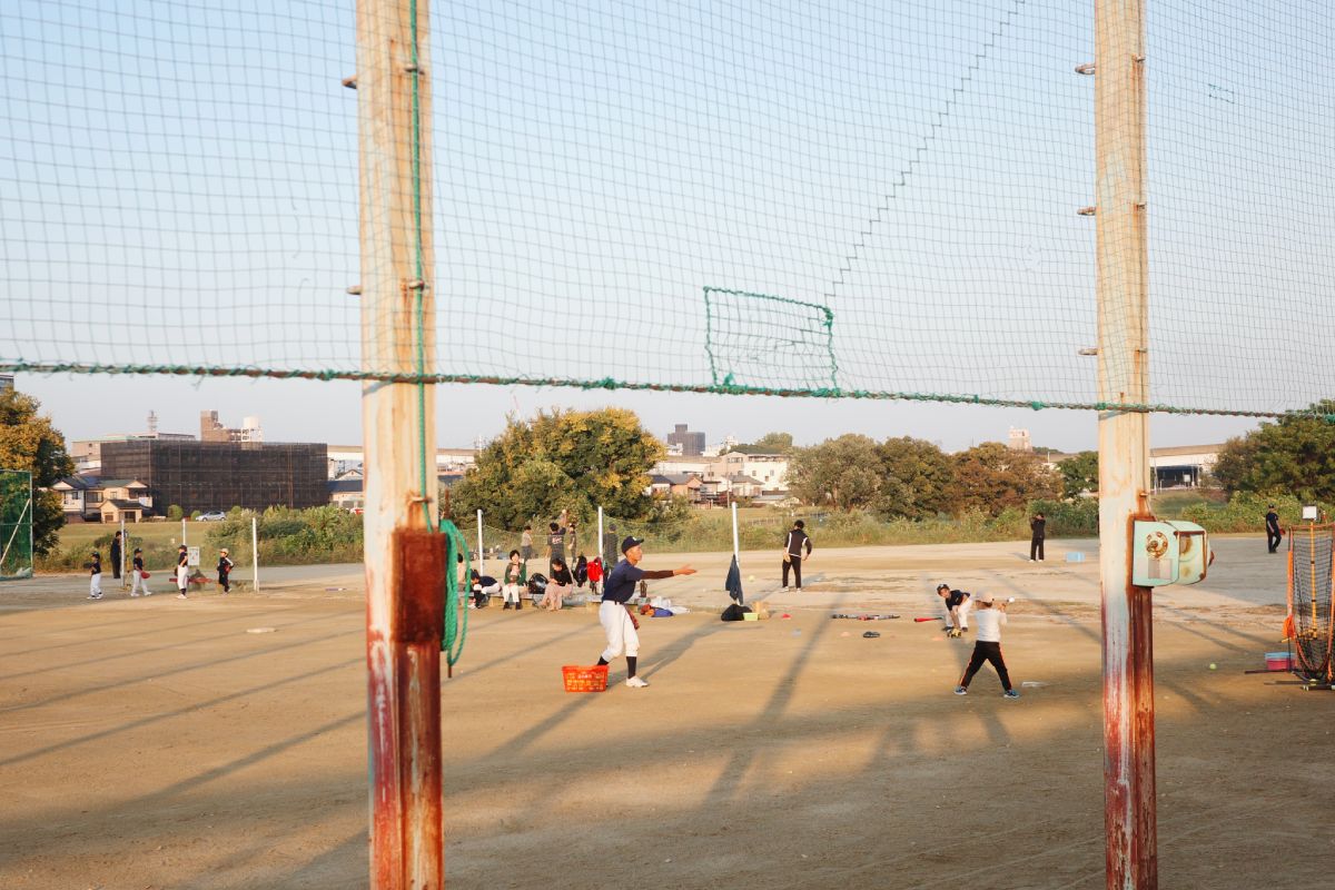 Young kids practicing their batting skills on the baseball field at Daikou Park by the Yada River, Higashi-ku, Nagoya, on a sunny day