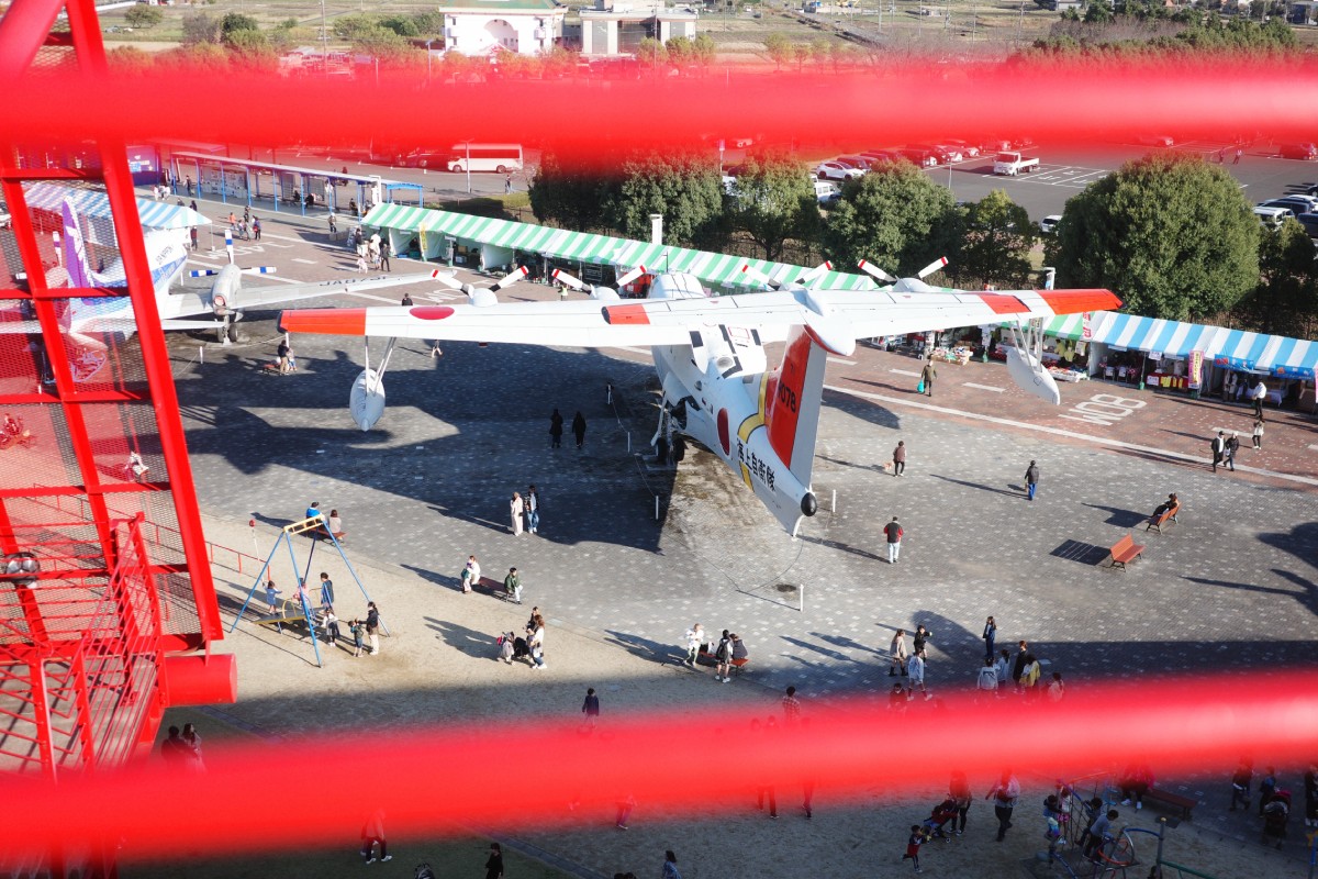 Exterior view of Gifu Kakamigahara Aerospace Museum with aircraft displayed in an outdoor park setting.