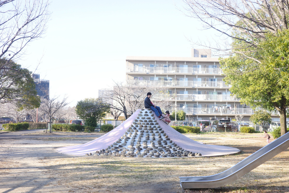 Dad sitting on the summit of the distinctive Mt. Fuji slide at Oseko Park along the beautiful Hori River.