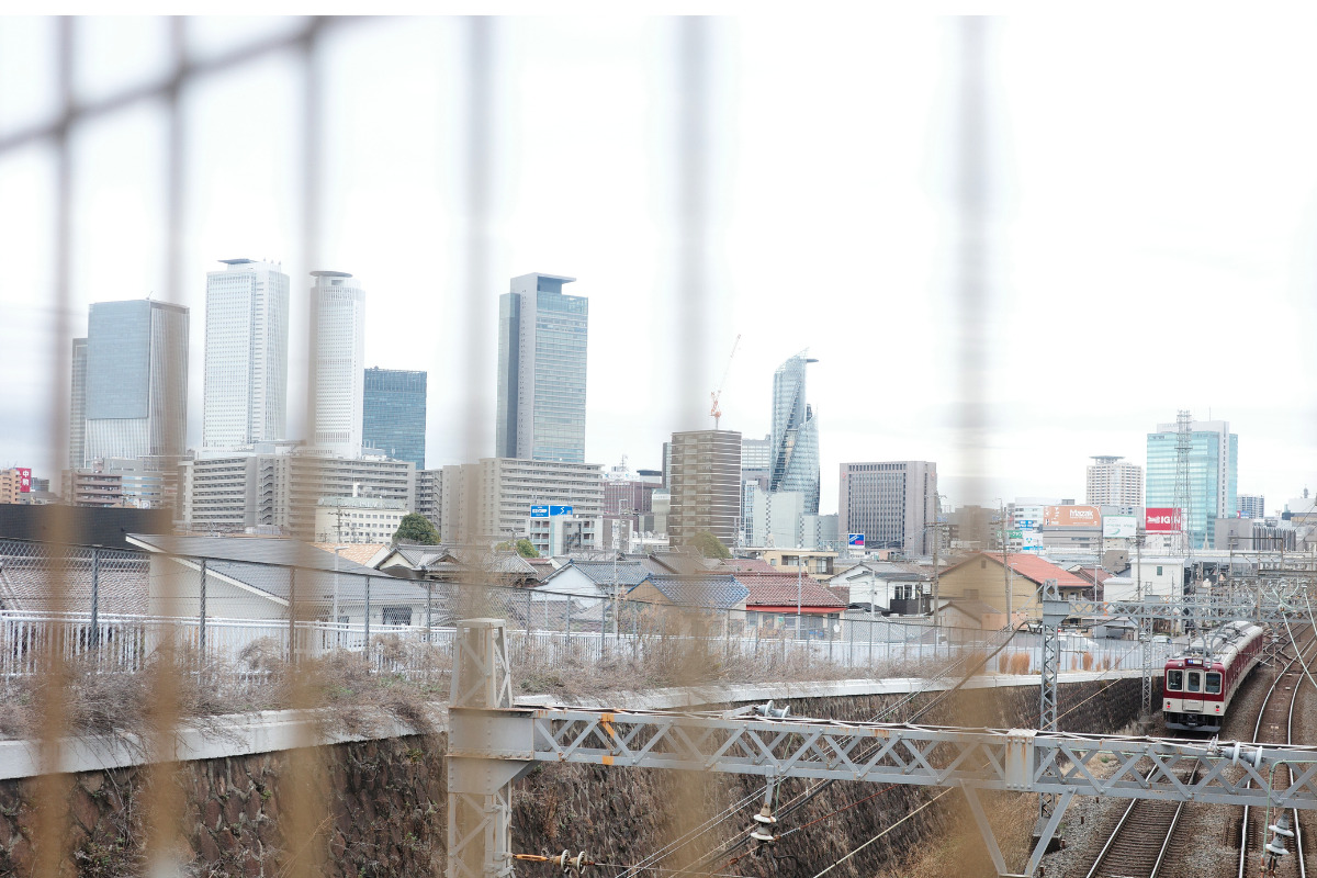 Hidden gems in Nagoya: Hidden charm of view Kintetsu train gracefully passing through Nagoya's cityscape with skyscrapers in the background.