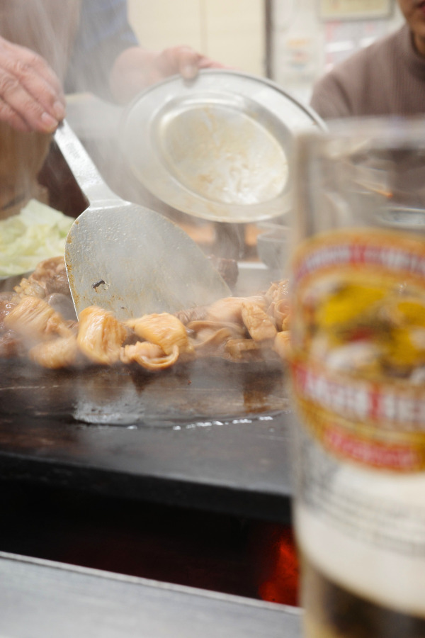 Sizzling Horumonyaki and refreshing beer - a mouthwatering duo capturing Nagoya's culinary essence.