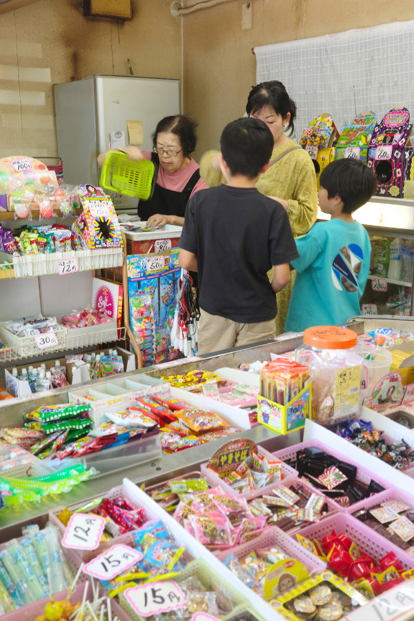 Inside Kantenya, a traditional dagashi-ya in Nagoya, showcasing Nagoya's local food and culture with children selecting their favorite candies.