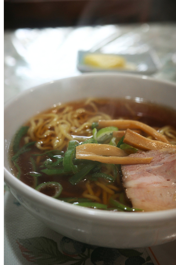 A bowl of Enraku's classic ramen, featuring rich broth, tender noodles, and fresh toppings, capturing the nostalgic essence of Nagoya's hidden gem.