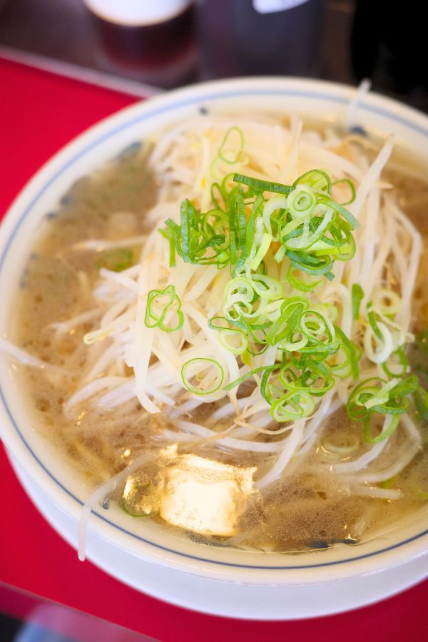 A delicious bowl of Ramen Fuku, featuring a mountain of bean sprouts and green onions, showcasing the hidden gem of ramen in Nagoya